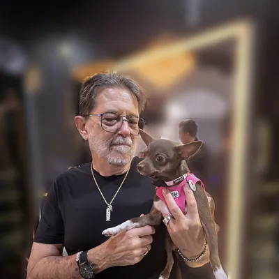 Demi in her pink harness, safe in Jimmy's arms at the salon